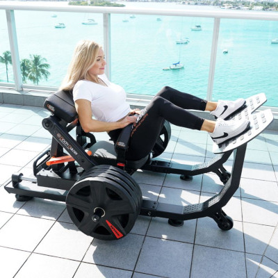 a blonde women using a booty builder fitness machine on a balcony