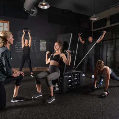 a group of people exercising with a fitbench machine