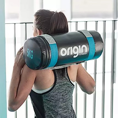 a women carrying an origin fitness sandbag on shoulders