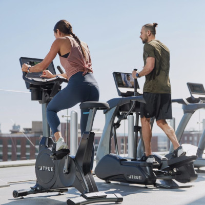 people exercising on true fitness cardio machines in the open air