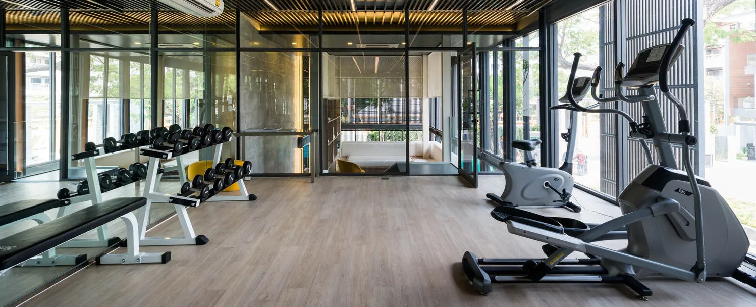 a home gym with wooden floor and exercise machines